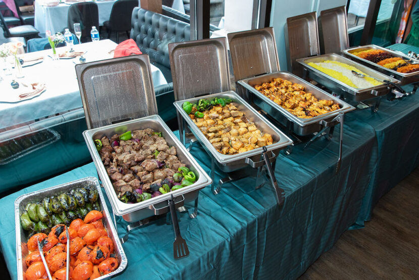 Bayshore Lounge catering buffet with grilled meats, rice, vegetables, and Mediterranean dishes for a private event in Newport Beach.