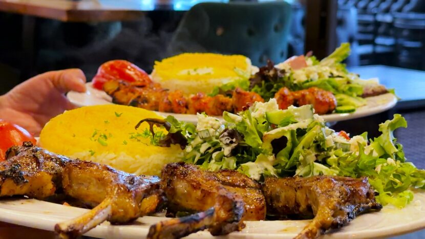 Persian-style kabob plates with saffron rice, salad, and grilled tomato, highlighting Bayshore Lounge’s Mediterranean-inspired dining in Newport Beach.