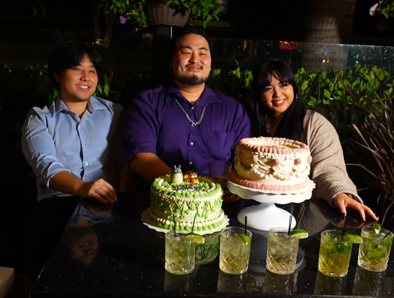 Guests posing for a birthday celebration photo with cake at Bayshore Lounge in Newport Beach